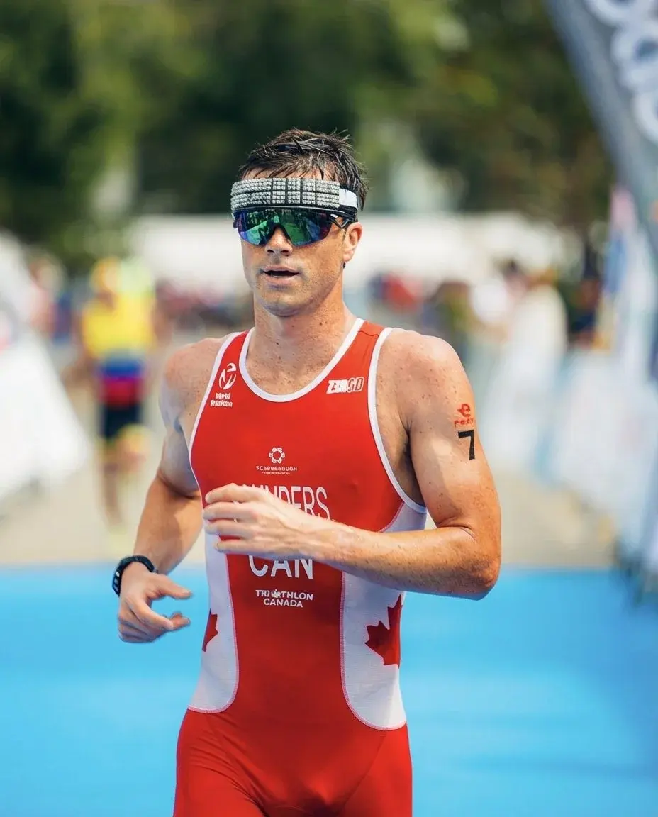 Coach Brett Saunders running in a Team Canada race suit