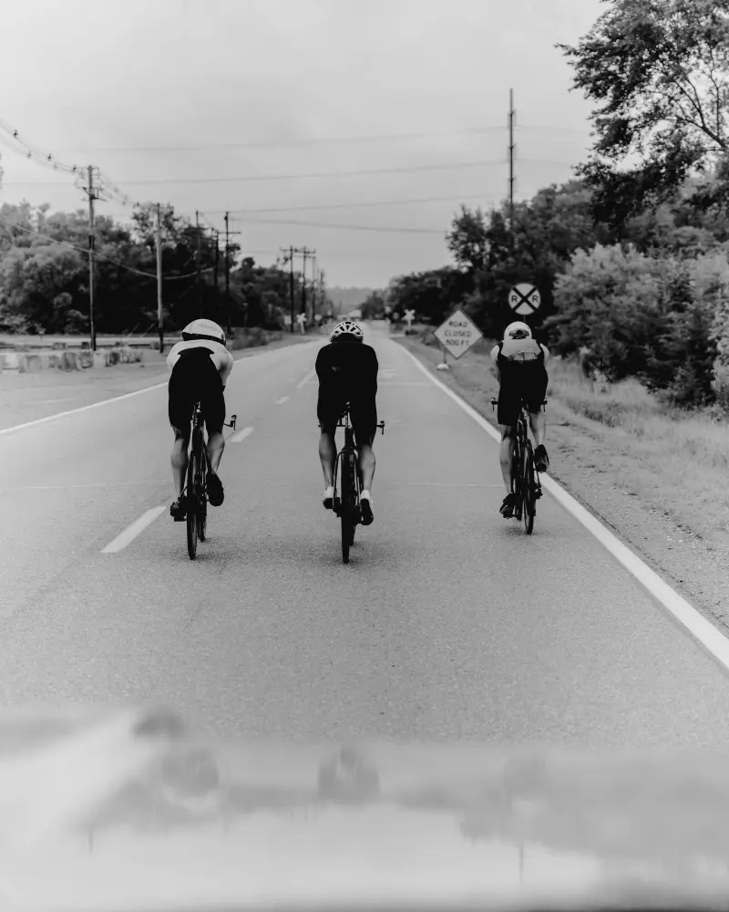 Three cyclists in black and white