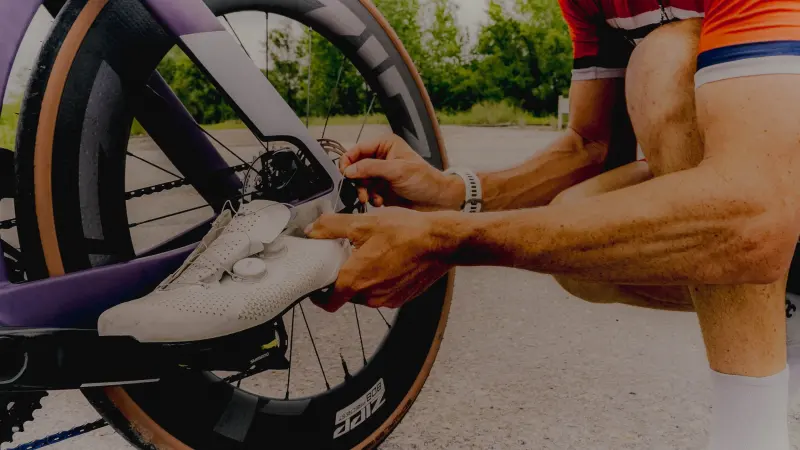 Close-up of hands adjusting a bike pedal and shoe