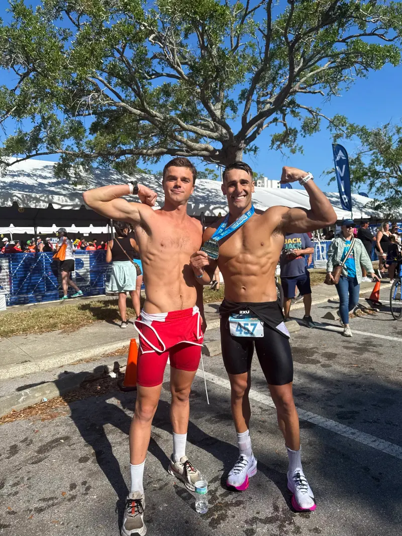 Two athletes with medals at a finish line